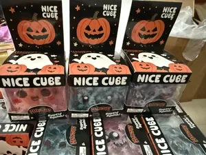 Detailed view of Halloween ghost and pumpkin squishy toy cubes in NICE CUBE packaging