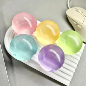 Close-up of five colorful translucent maltose stress relief balls on a white tray