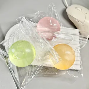 Detailed view of three translucent green, pink, and yellow stress relief balls in clear bags