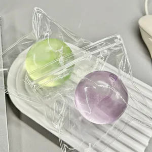 Detail view of green and purple transparent stress relief squishy balls in packaging.