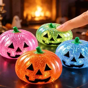 Macro detail of colorful glitter Halloween pumpkin squishies being squeezed for stress relief.