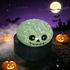 Juguete antiestrés de calavera de Halloween brillante con textura agrietada sobre fondo oscuro.
