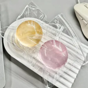Stress-relieving coconut oil squishy toy balls in pink and yellow with clear packaging