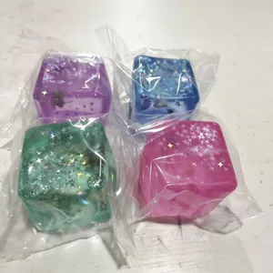 Detail view of four colorful maltose ice cube squishy toys in clear plastic wrap