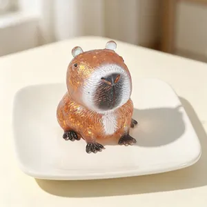 Primo piano di un giocattolo squishy capibara con glitter dorati e imbottitura morbida.