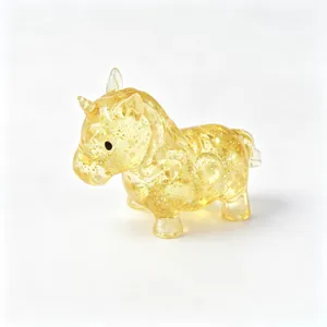 Close-up of a yellow translucent unicorn squishy toy filled with sparkling gold glitter