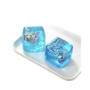 Light blue maltose ice cube squishy toy with decorative marine shells and stars