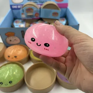 Primo piano di una mano che tiene un giocattolo antistress baozi squishy rosa glitter
