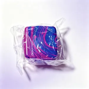Detail view of blue and pink marble patterned square squishy toy in plastic wrap