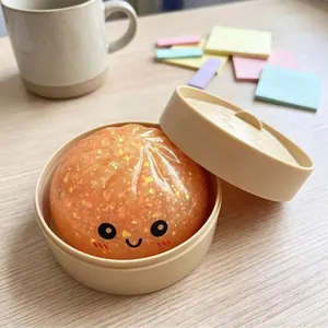 Primo piano di un giocattolo antistress a forma di panino arancione glitterato con sorriso