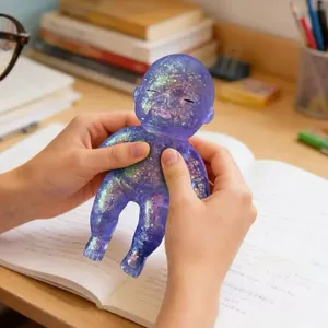 Violetter Glitzer-Baby-Stressabbau-Squishy-Spielzeug, das auf einem Schreibtisch gedrückt wird