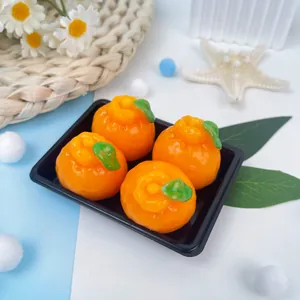 Vue détaillée de quatre jouets antistress en forme d'orange sur un petit plateau noir.