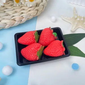 Gros plan de quatre jouets squishy fraise réalistes dans un plateau