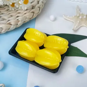 Gros plan sur quatre jouets à presser en forme de caramboles jaunes sur un plateau.