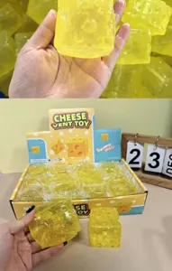 Nahaufnahme eines gelben quadratischen Käse-Quetschspielzeugs mit Verkaufsverpackung