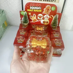 Dettaglio del giocattolo squishy di Natale con paillettes rosse e fiocco dorato