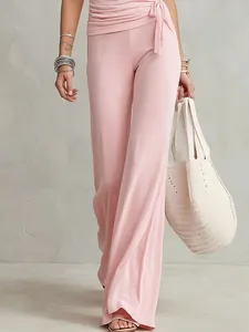 Vista dettagliata del set rosa con pantaloni a vita alta e top elegante stile portafoglio.