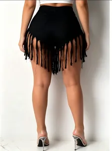 Close-up view of back detail showing long fringe tassels on black denim shorts