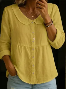 Detailansicht einer gelben Baumwoll-Leinen-Bluse mit Bubikragen und Knopfleiste vorne