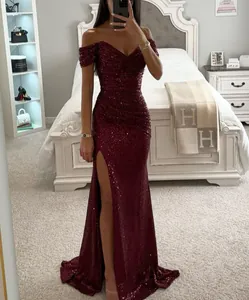 Detailed view of the sparkling burgundy sequined evening gown with a high leg slit