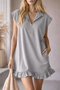 Detail view of grey sleeveless dress featuring zipper V-neck and ruffled hemline