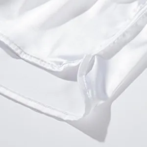 Nahaufnahme der weißen Satin-Herrenshorts mit Seitenschlitz und feinen Nähten.