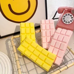Realistic chocolate bar slow rebound squishy toy for stress relief in pink and yellow colors.