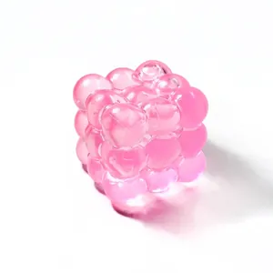 Detail of pink translucent cube squishy toy with a glossy bubbly texture for stress relief.