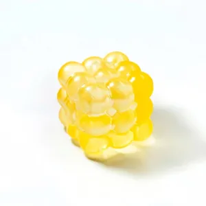 Macro view of yellow translucent cube squeeze toy with unique soft bubble texture.