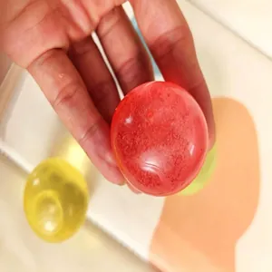 Red and yellow 6cm maltose squishy balls for stress relief and sensory play.