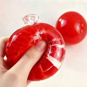 Nahaufnahme einer Hand, die einen roten knusprigen Stressball mit Textur zusammendrückt