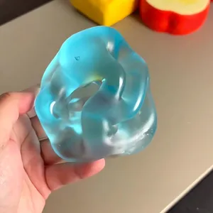 Gros plan d'un jouet anti-stress bleu translucide pressé à la hand pour se détendre.