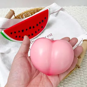 Close-up view of a pink peach squishy slow rebound toy held in hand for stress relief