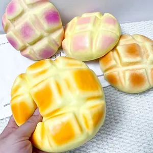 Gros plan d'une main pressant un jouet squishy en forme de pain brioché à rebond lent