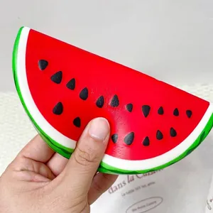 Detailed view of a watermelon squishy toy held in hand showing PU texture.