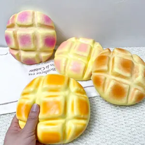 Détail montrant la texture d'un grand jouet squishy pain à l'ananas à rebond lent en main