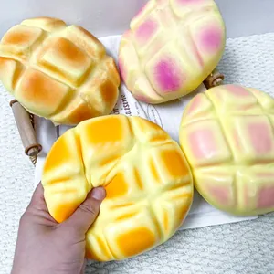 Gros plan d'une main pressant un jouet spongieux en forme de pain à l'ananas géant