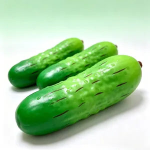 Detailed view of three green cucumber squishy toys with realistic water droplets