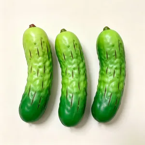 Close-up of three green pickle squishy stress relief toys on a plain white background.