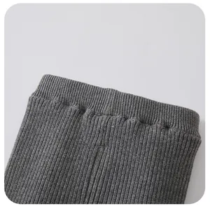 Détail macro du tissu en maille côtelée grise montrant la texture de la taille élastique.