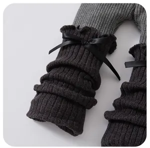 Détail de leggings côtelés pour bébé avec nœud noir décoratif et bords à volants