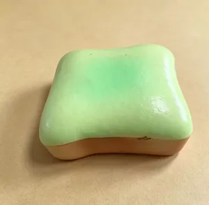 Close-up view of a green butter toast bread slow rebound squishy stress relief toy.