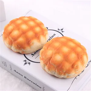 Detail showing the realistic texture of two PU squishy pineapple bread toys on a book