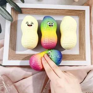 Detail view of a rainbow peanut squishy toy being squeezed to show slow rebound texture