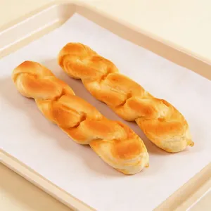 Detailed macro view of two golden twisted PU squishy bread toys on a baking tray
