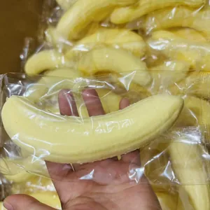 Detailed view of a realistic yellow banana squishy toy held in hand to show soft texture