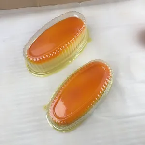 Detail view of two oval cheese bread squishies in clear packaging on a white surface.