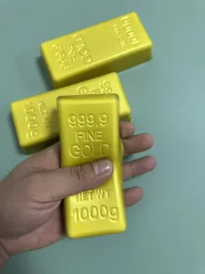 Close-up of a hand squeezing a soft slow-rebound gold bar-shaped toy