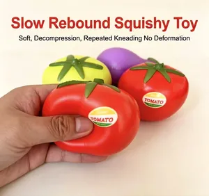 Macro view of a hand squeezing a red tomato squishy toy showing its slow rebound texture