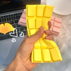 Macro view of hand squeezing a yellow chocolate-shaped slow rebound squishy toy